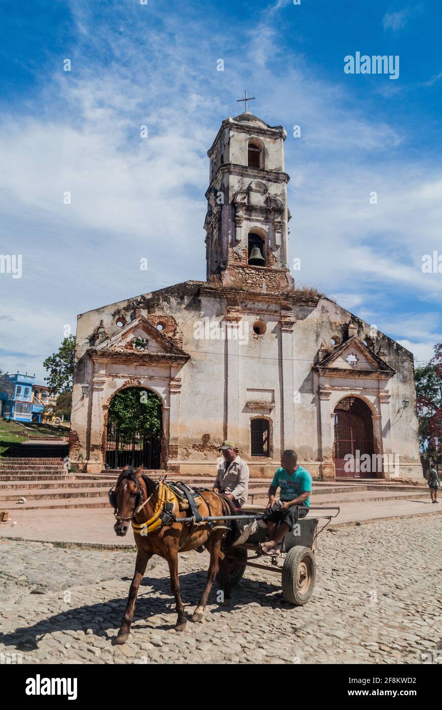 TRINIDAD, CUBA - 8 FEBBRAIO 2016: Passeggiate in carrozza di fronte alle rovine della chiesa di Santa Ana nel centro di Trinidad, Cuba. Foto Stock