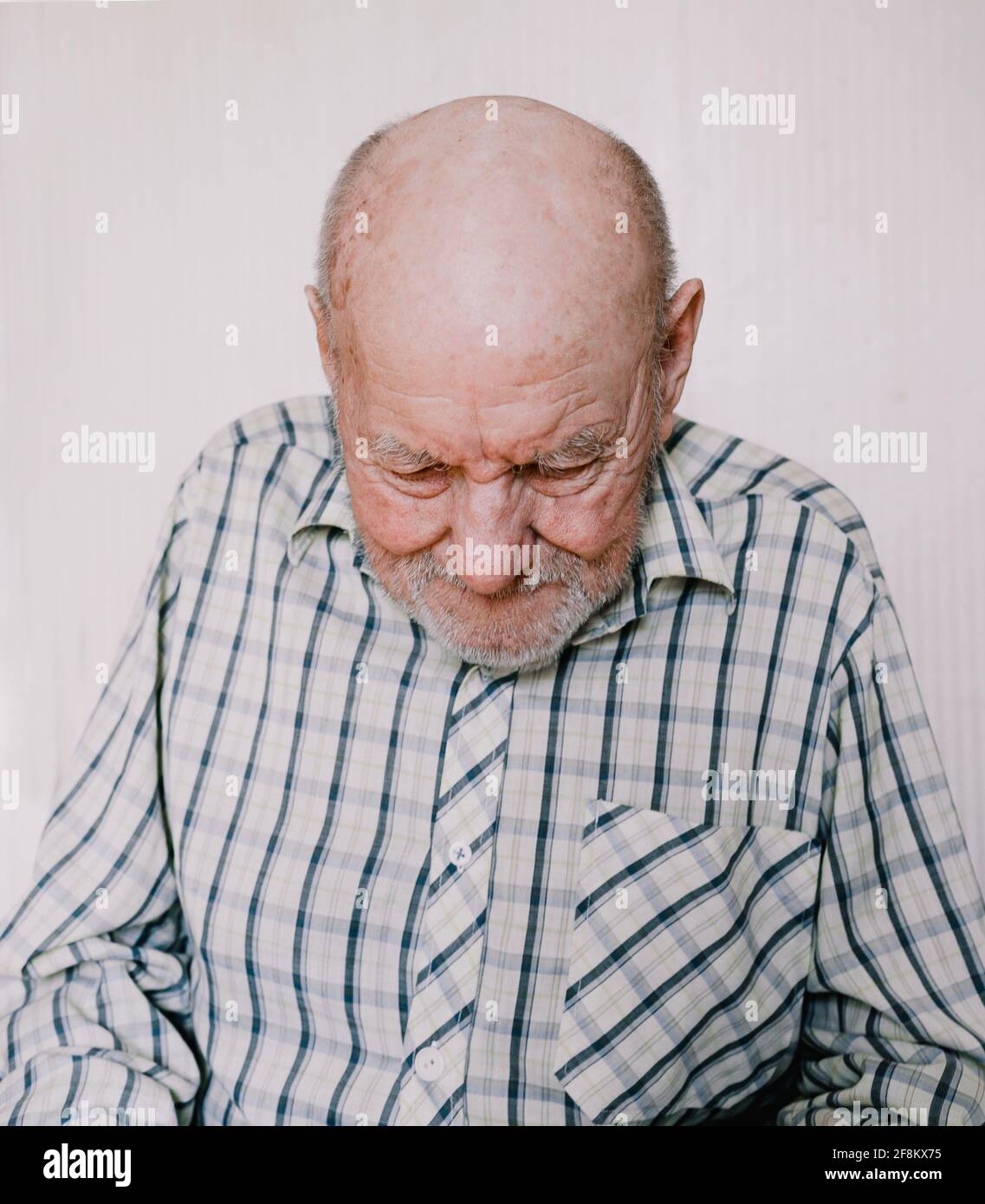 un grande ritratto di un vecchio su uno sfondo chiaro con profonde rughe, macchie di età. Foto Stock