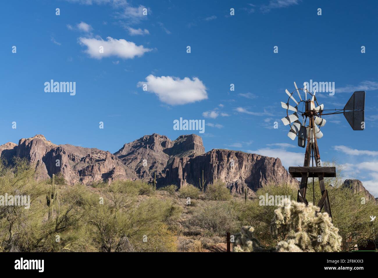 Un antico mulino a vento in legno con la Superstition Mountain sullo sfondo al Superstition Mountain Museum in Arizona. Foto Stock