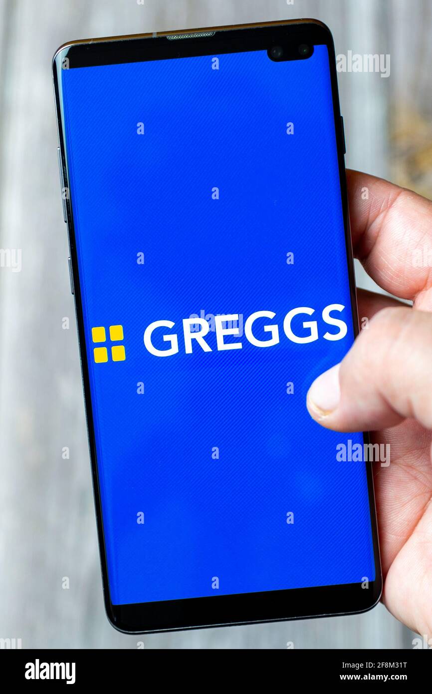 Un telefono cellulare o un telefono cellulare in attesa in un Mano che mostra l'applicazione Greggs sullo schermo Foto Stock