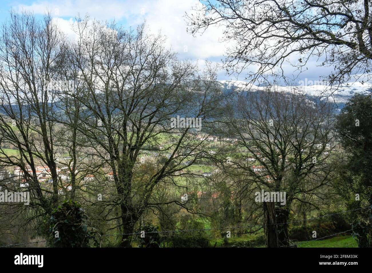 Valle tipica dei Paesi Baschi con le montagne innevate sullo sfondo Foto Stock
