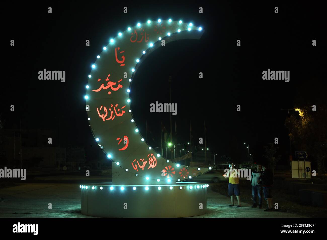 Amman, Giordania. 14 Apr 2021. La gente si trova accanto ad una decorazione del Ramadan durante il mese santo islamico del Ramadan ad Amman, Giordania, il 14 aprile 2021. Credit: Mohammad Abu Ghosh/Xinhua/Alamy Live News Foto Stock