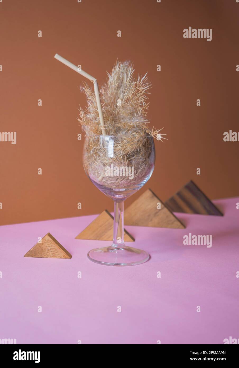 Pampas cocktail d'erba in un bicchiere con una paglia di pampas stelo. Sfondo minimo della composizione astratta. Japandi idea interiore. Idea di rinfresco. Foto Stock