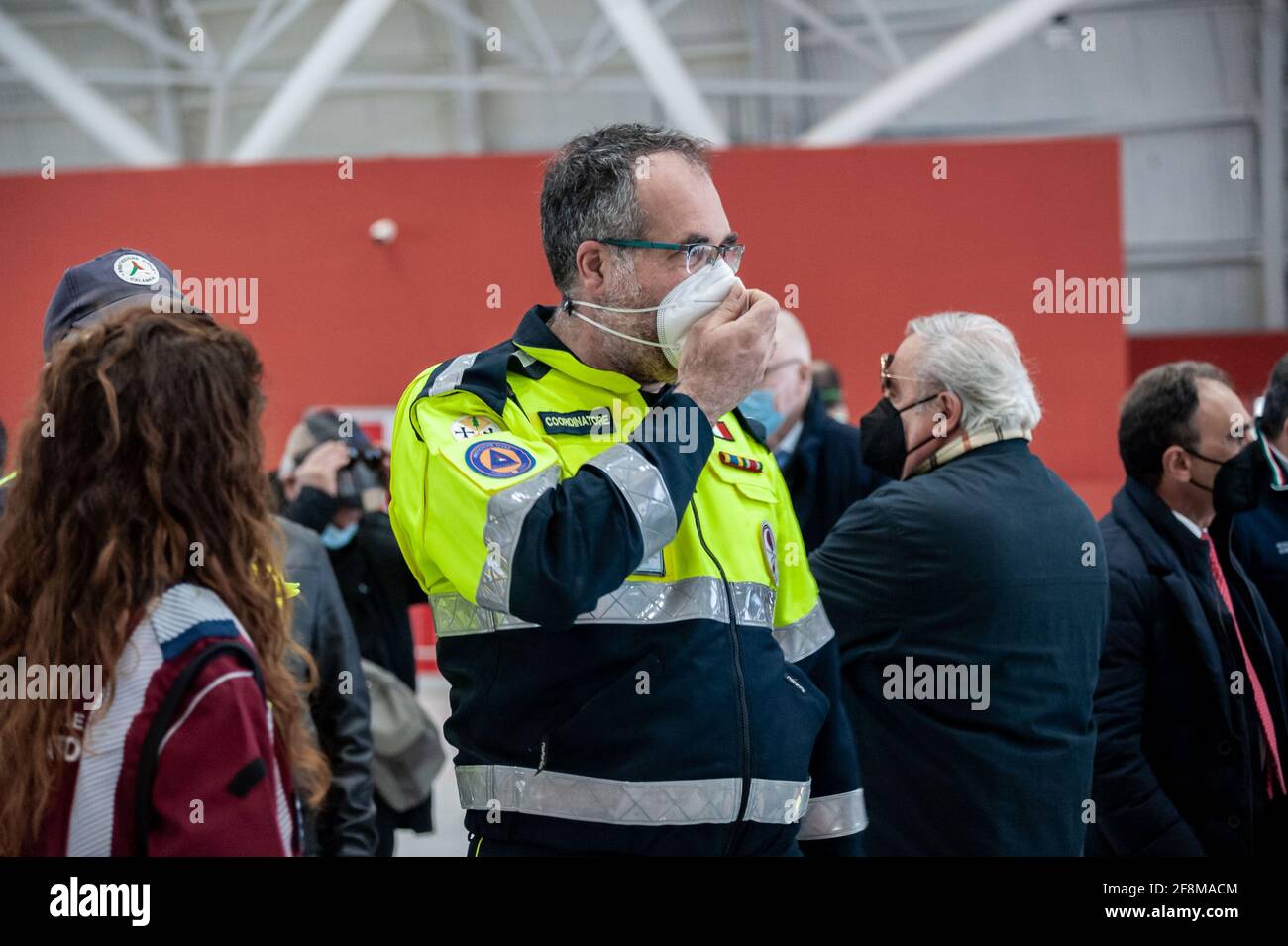 Pierpaolo Pizzoni (c), coordinatore della squadra locale della protezione civile italiana, visto durante l'inaugurazione. È stato inaugurato il COVID-19 Vaccine Hub, allestito presso il Centro Fieristico di Catanzaro Lido, considerato il più grande della regione, potenzialmente può avere la capacità di effettuare 2,500 vaccinazioni al giorno. Diverse autorità regionali e locali hanno partecipato all'evento e il personale di organizzazioni caritative ha ricevuto il vaccino AstraZeneca. Foto Stock