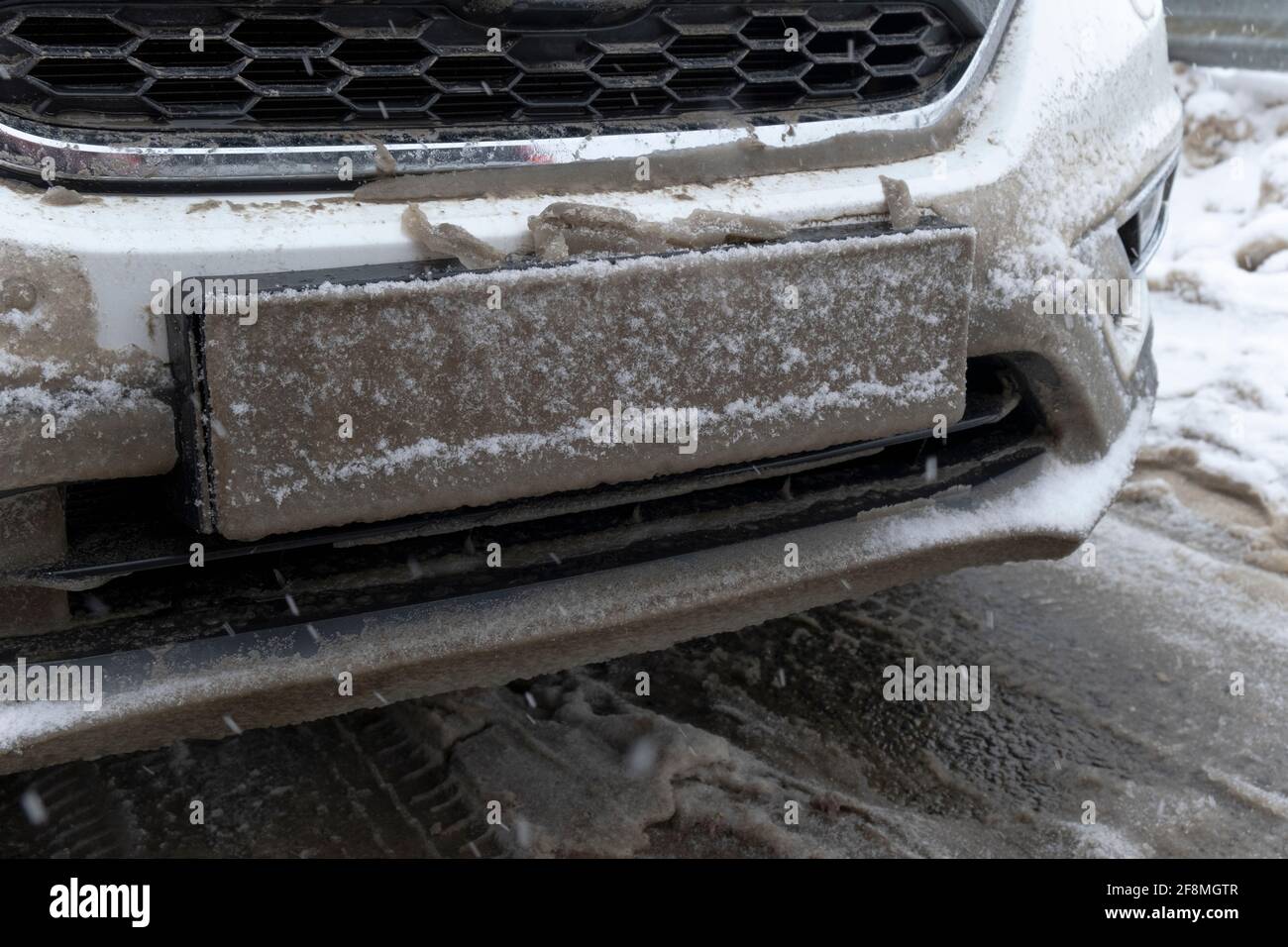 La targa di immatricolazione del veicolo è coperta da neve sporca. Pericolo per i partecipanti al traffico. Hiden incognito Invisible trasporto automobilistico reg Foto Stock