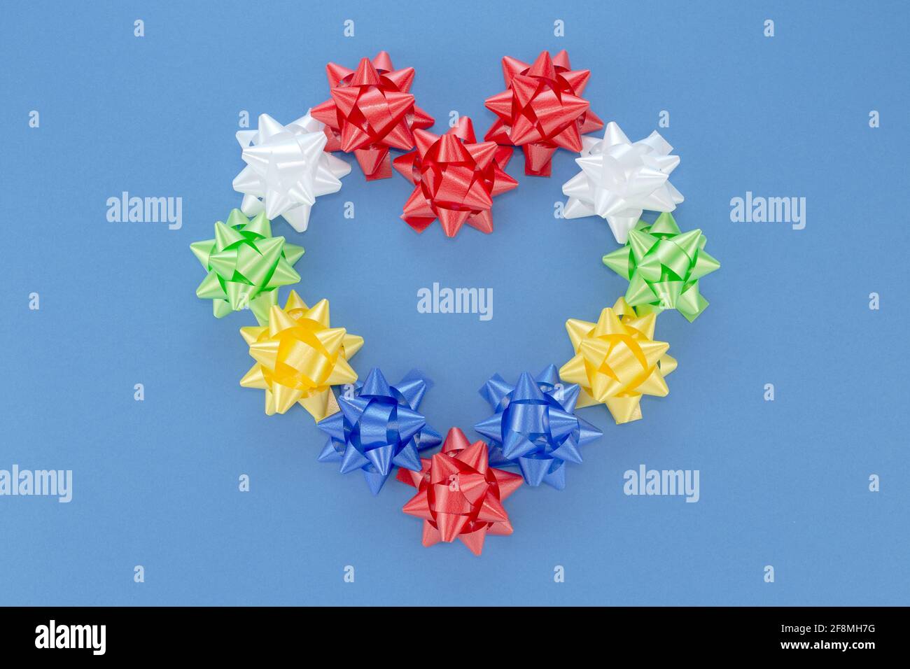 Concetto di San Valentino cuore d'amore festivo dalla colorata rosa artificiale Fiori nastro di plastica per decorazione regalo in posa piatta con Spin copia mockup Foto Stock