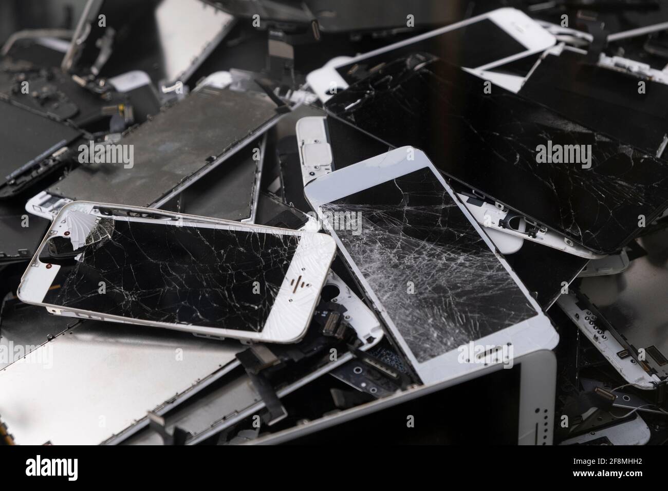 Telefono cellulare Smart rotto e pad con schermo LCD in vetro schiantato. Gadget giacenti uno sopra l'altro. I dispositivi sono pronti per l'utilizzo. Foto Stock