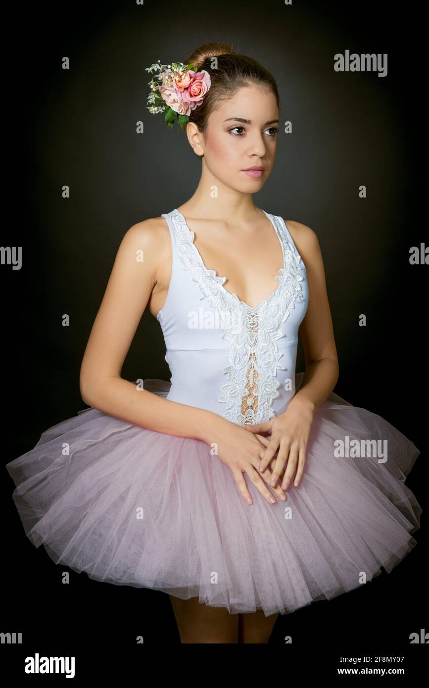 Ballerina giovane con trucco leggero e capelli legati decorati con fiori su  sfondo scuro Foto stock - Alamy