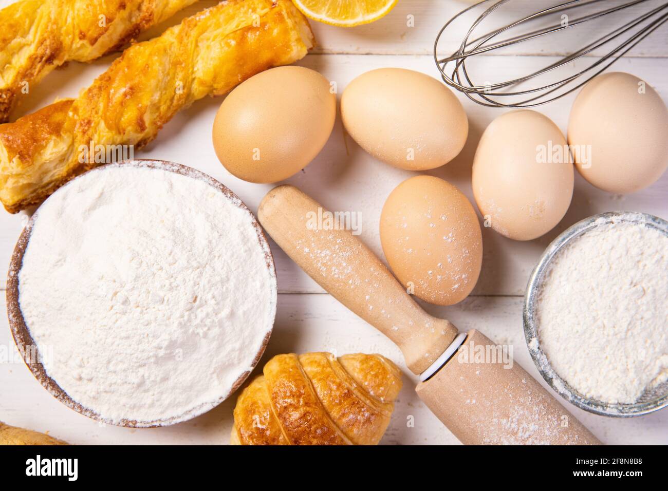 Vista dall'alto di croissant e altri dolci con ingredienti un tavolo di legno in cucina Foto Stock