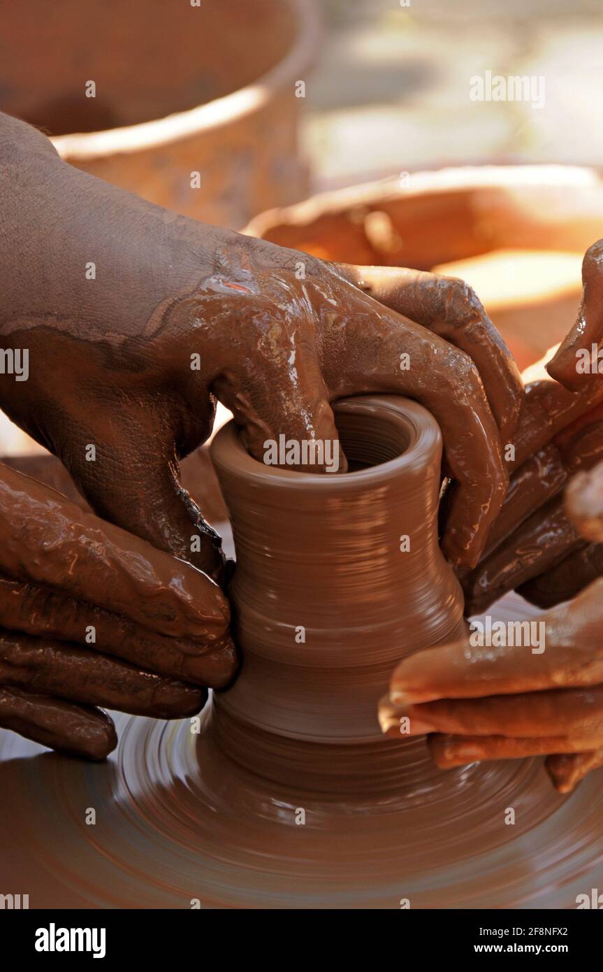Insegnante e capretto che fanno la pentola di ceramica sulla ruota di ceramica Foto Stock
