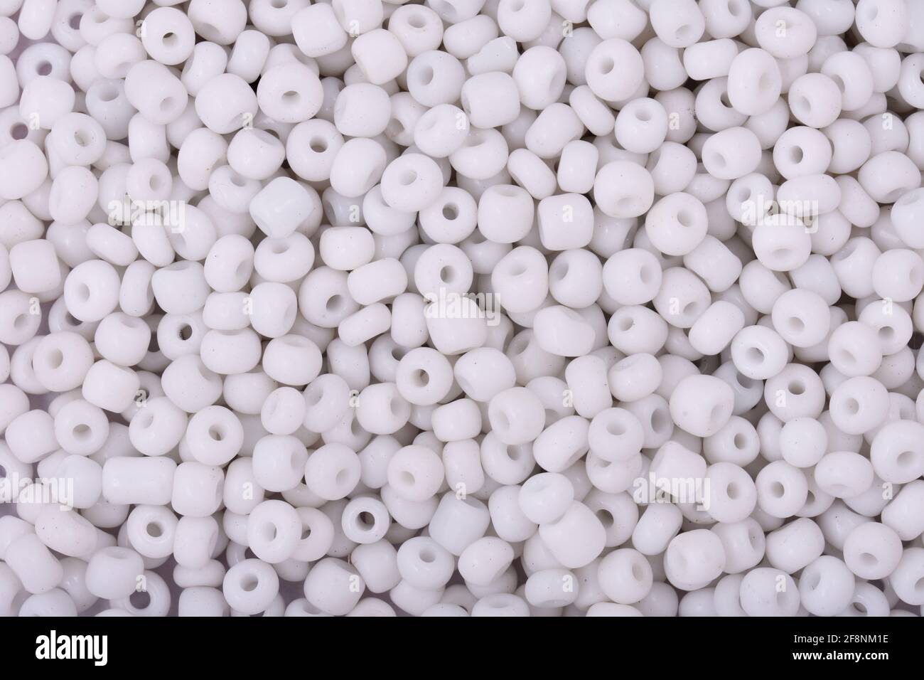 Perline bianche sullo sfondo bianco primo piano, macro, Crea collana di  perline Foto stock - Alamy