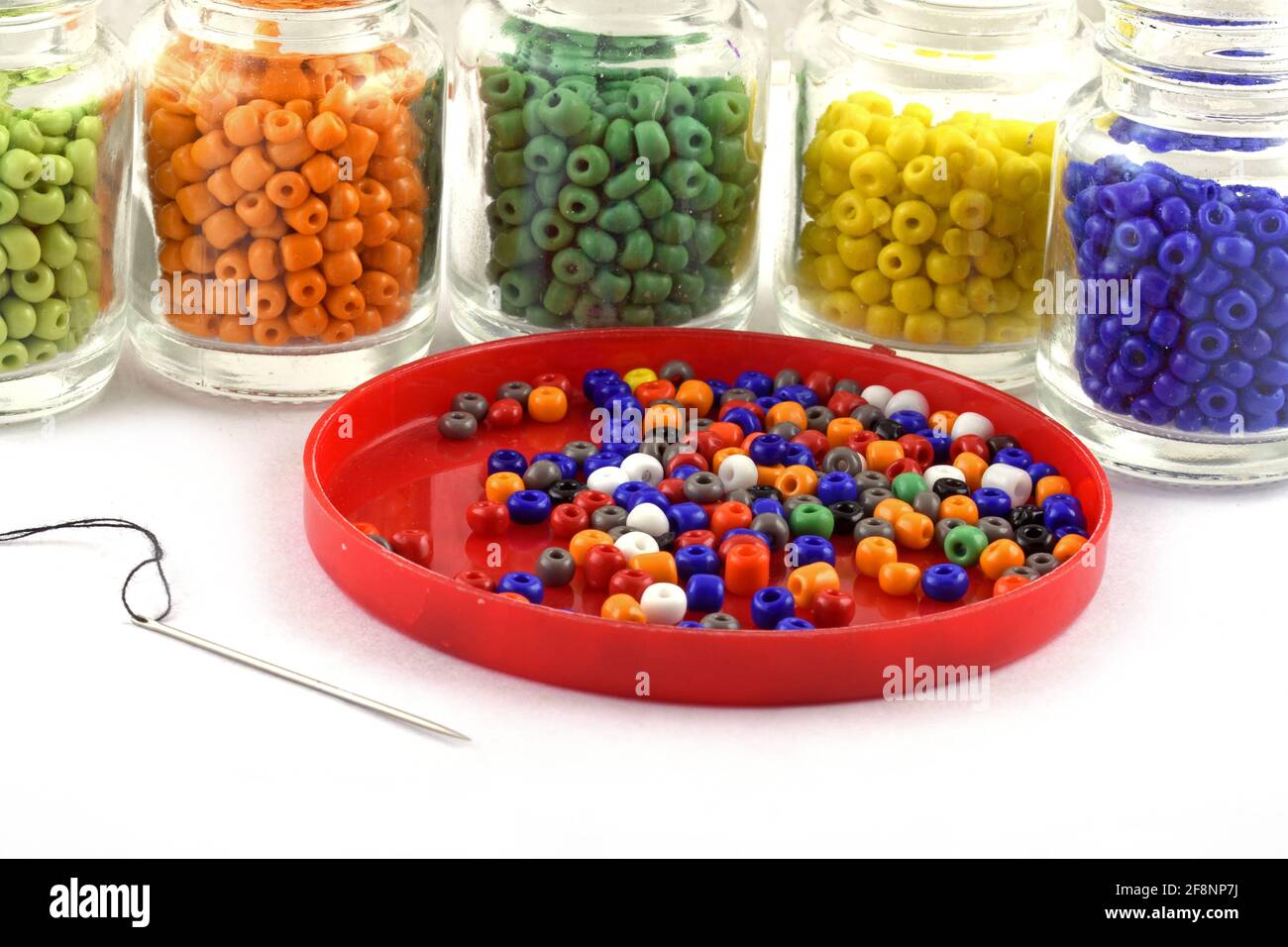 Perline colorate con ago perline in bottiglia usate per rifinire i vestiti di moda fanno collana di perline, perline per donne di moda, perline crochet Daily Beading Foto Stock
