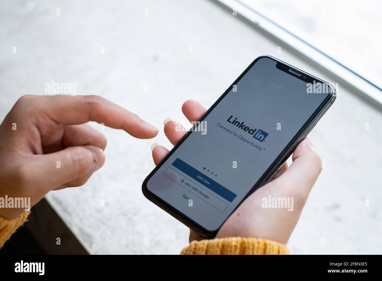 CHIANG mai, THAILANDIA Apr 27 2021 : UNA donna tiene Apple iPhone con l'applicazione LinkedIn sullo schermo.LinkedIn è un'app per la condivisione di foto per smartphone. Foto Stock