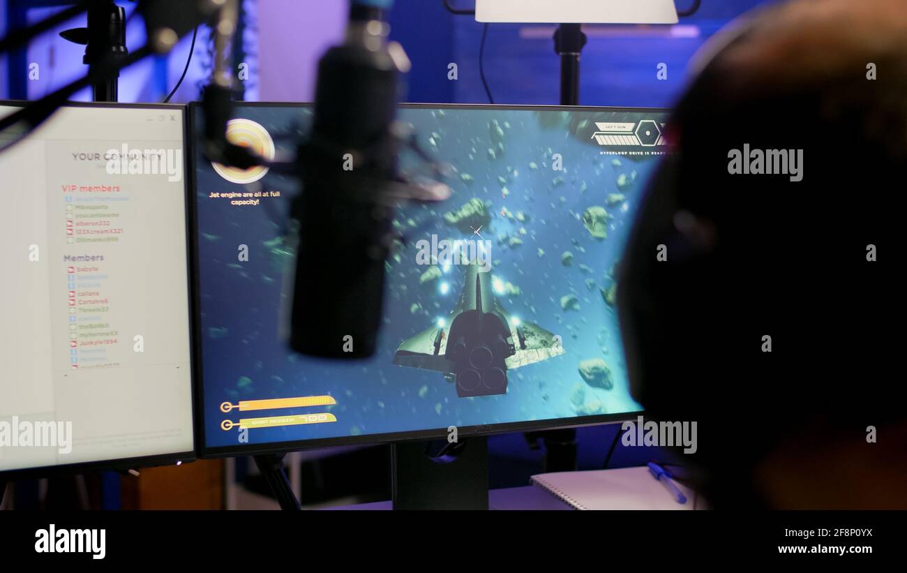 Game over per pro streamer giocare online vide spazio di gioco sparatutto in streaming stanza utilizzando moderno headseat. Cyber prestazioni su un potente pc parlare con i giocatori in chat aperto durante la competizione professionale Foto Stock
