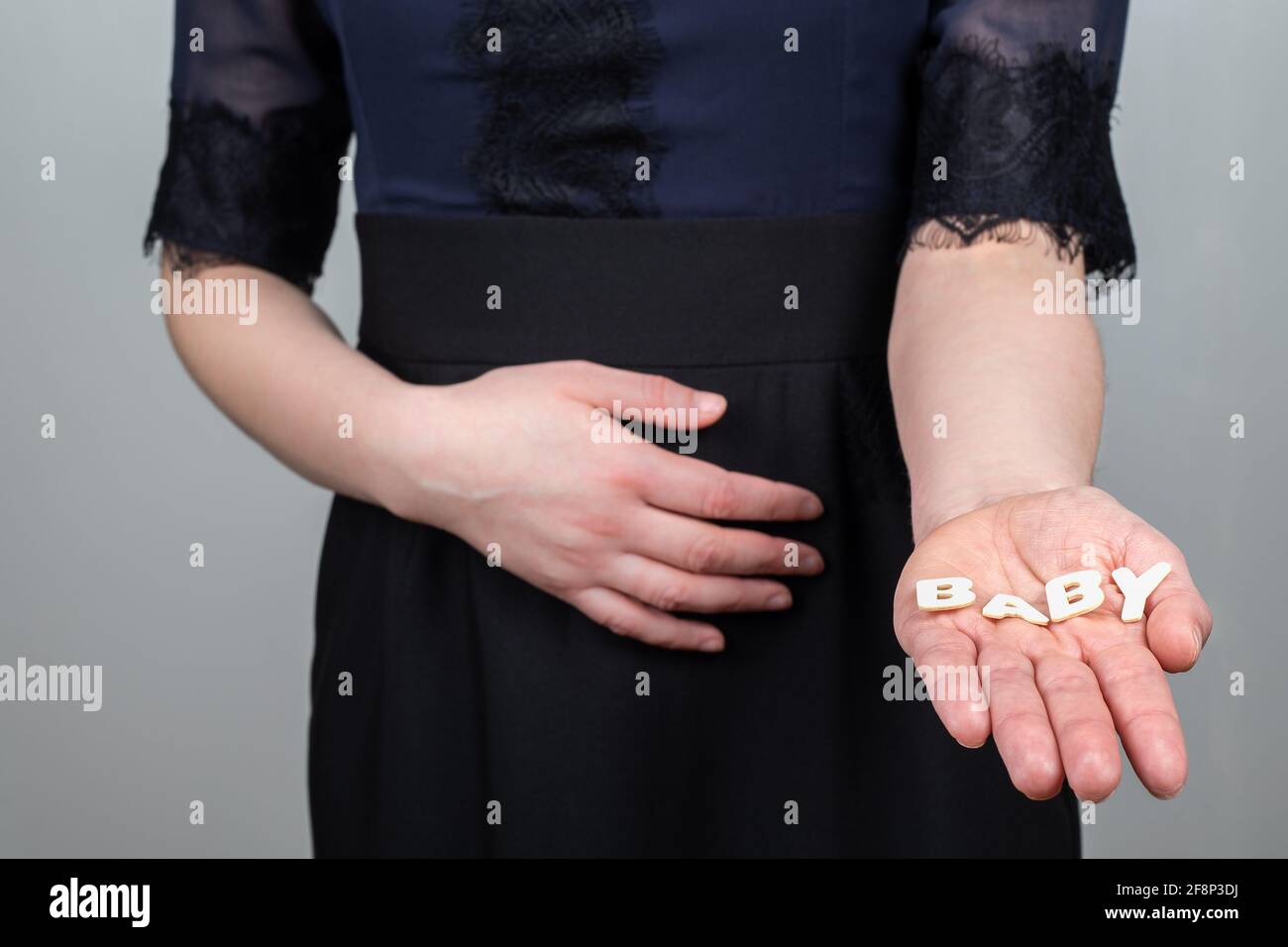 Donna incinta. Word Baby da lettere alfabetiche in legno. Foto Stock
