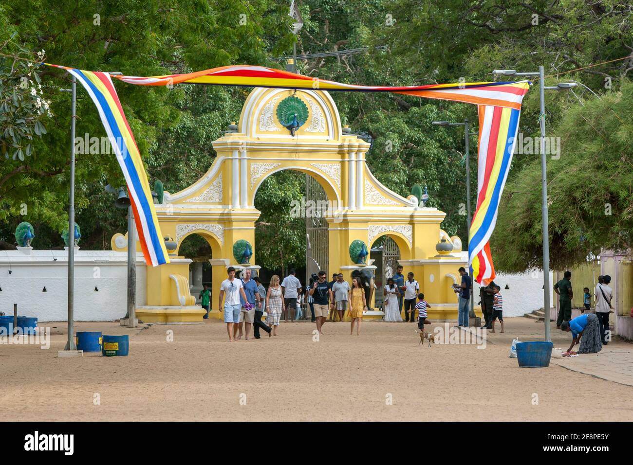 I visitatori camminano oltre gli archi di ingresso principali al tempio di Kataragama nello Sri Lanka meridionale. Foto Stock