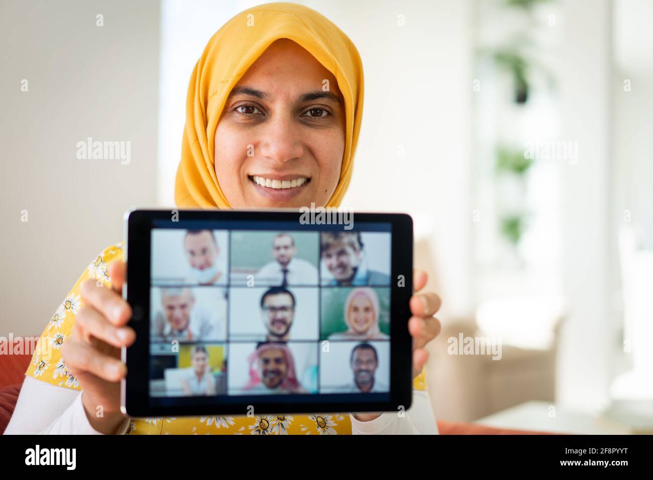 Mussulmana womah che tiene il tablet con lo schermo di conferenza zoom Foto Stock