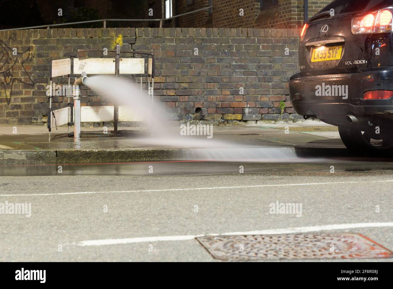 L'acqua del Tamigi fuoriesce dalla strada e scende lungo il canale, la Lewisham High Road, a sud-est di Londra, Inghilterra Foto Stock