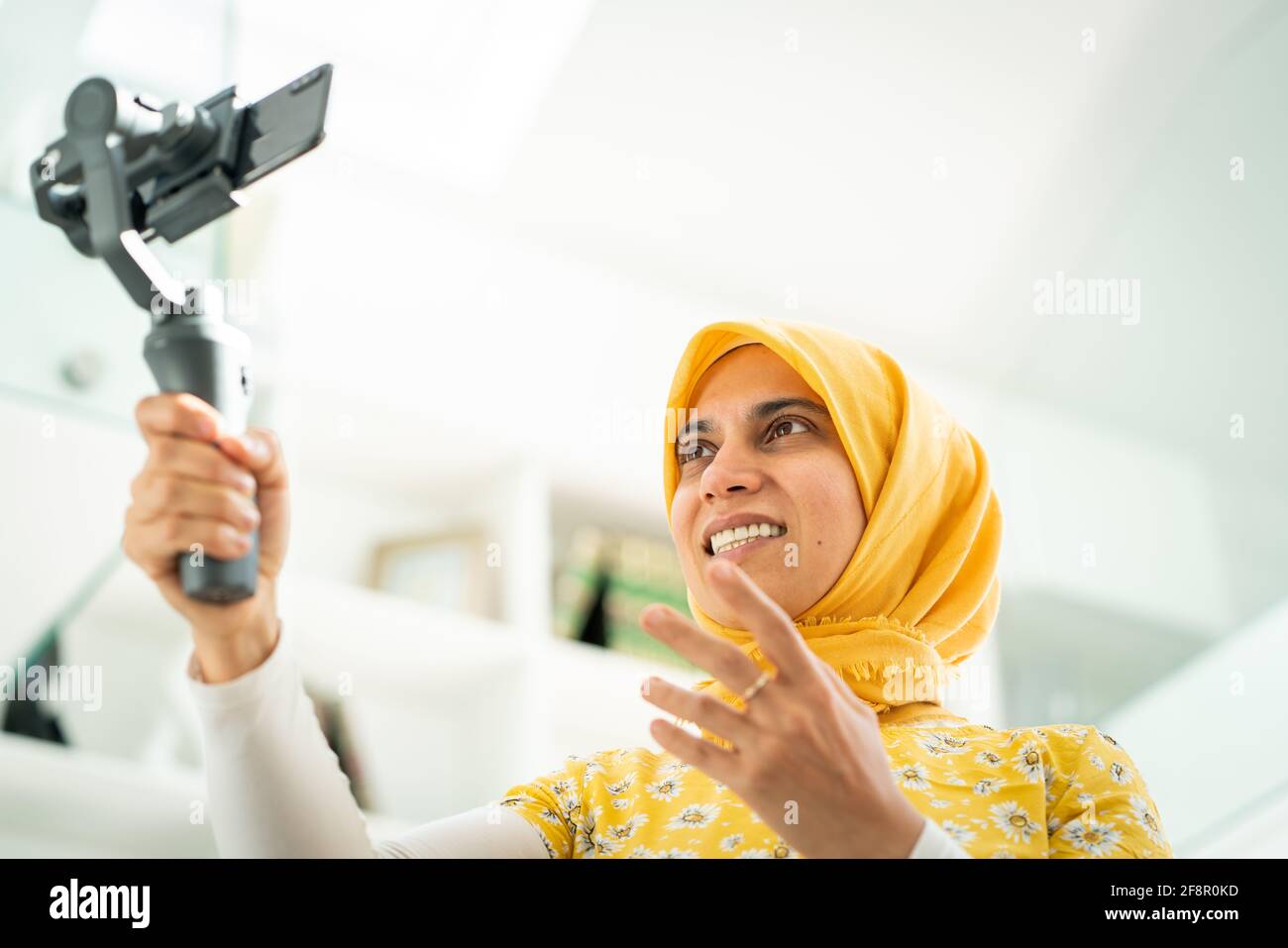 Donna musulmana che trasmette contenuti video online a casa Foto Stock
