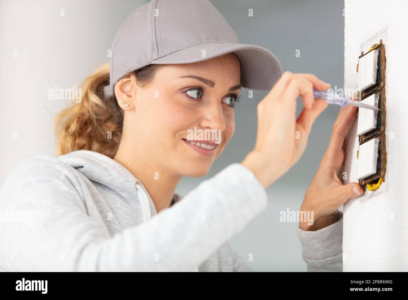 donna installanuova presa nella parete Foto Stock