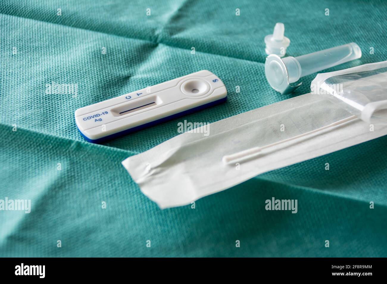 COVID-19 Kit Rapid Antigen Test su fondo chirurgico verde, pronto per l'uso. Concetto di un'ampia strategia di test per far fronte alla pandemia. Foto Stock