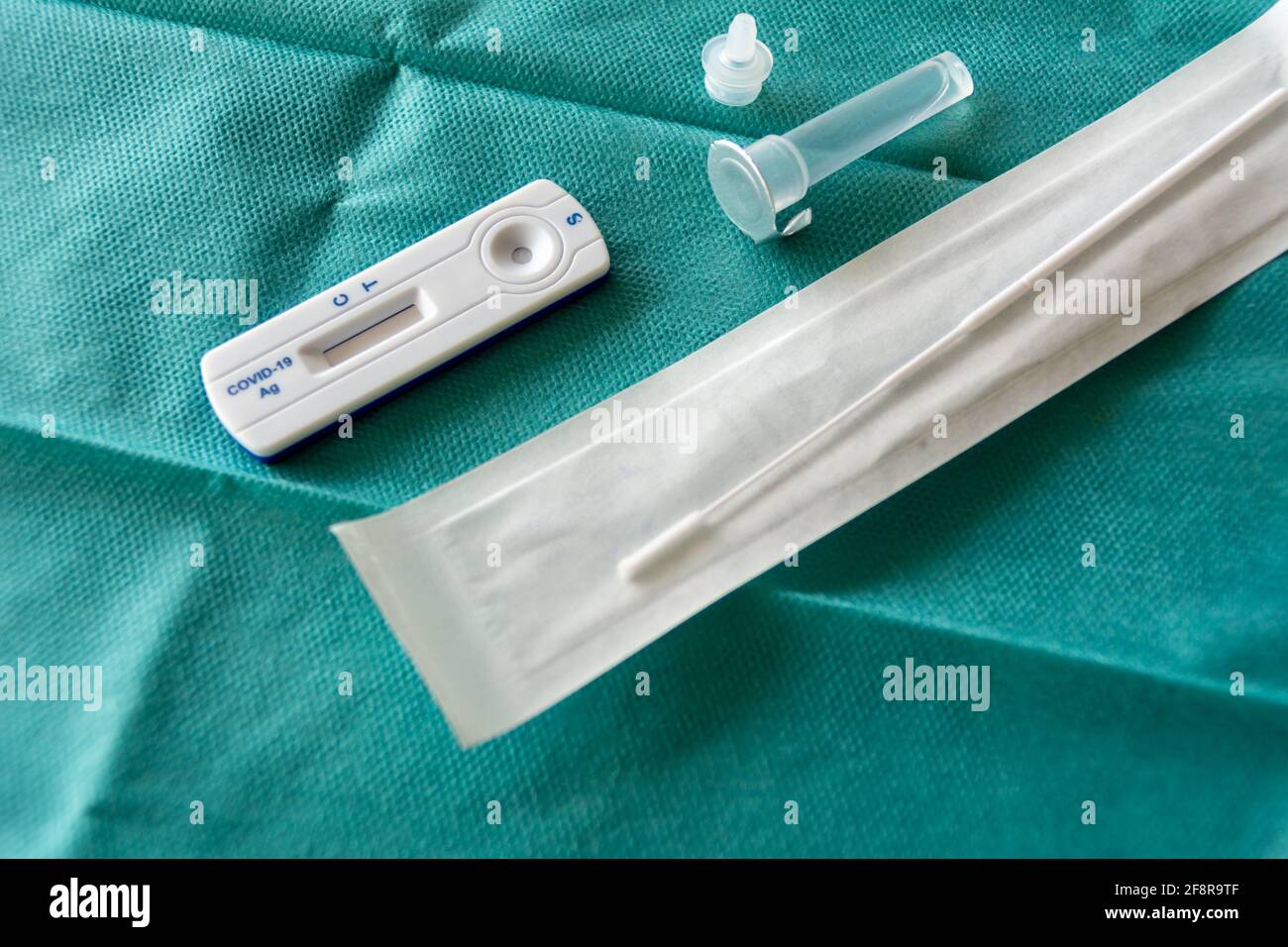 COVID-19 Kit Rapid Antigen Test su fondo chirurgico verde, pronto per l'uso. Concetto di un'ampia strategia di test per far fronte alla pandemia. Foto Stock
