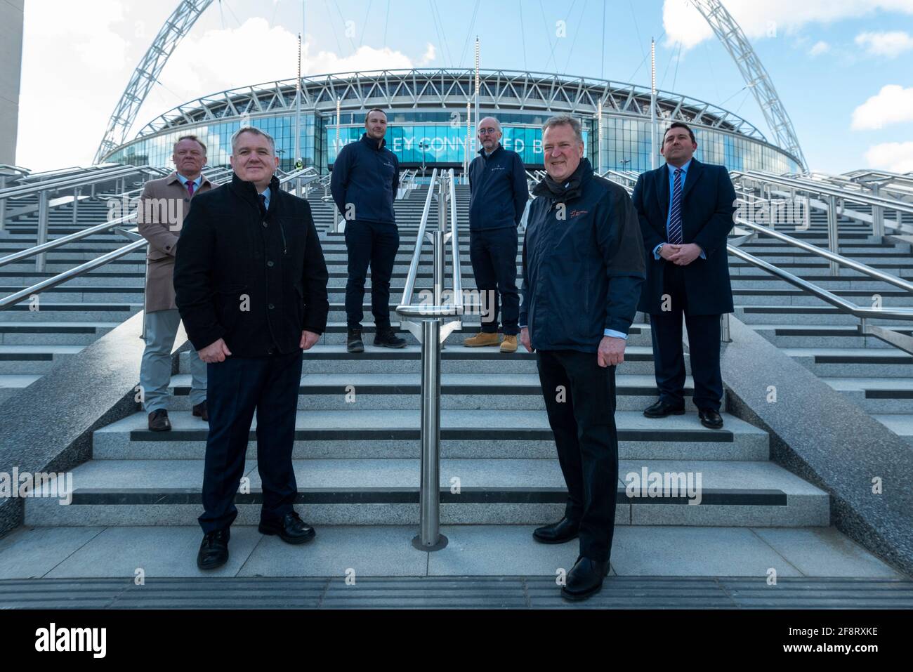 Londra, Regno Unito. 15 aprile 2021. (Prima fila, da L a R) Stephen Daniels, direttore delle operazioni, e James Saunders, amministratore delegato di Quintain di fronte ai dirigenti della fotocellula sulla prossima fase olimpica di Wembley Stadium. La scalinata olimpica 48 comprende 4 voli di 12 gradini e diventerà la nuova porta di accesso allo stadio per i visitatori e i tifosi che arrivano dalla Olympic Way e sarà completata nel giugno 2021 in tempo per le partite di gruppo in Inghilterra a Euro 2020. Credit: Stephen Chung / Alamy Live News Foto Stock