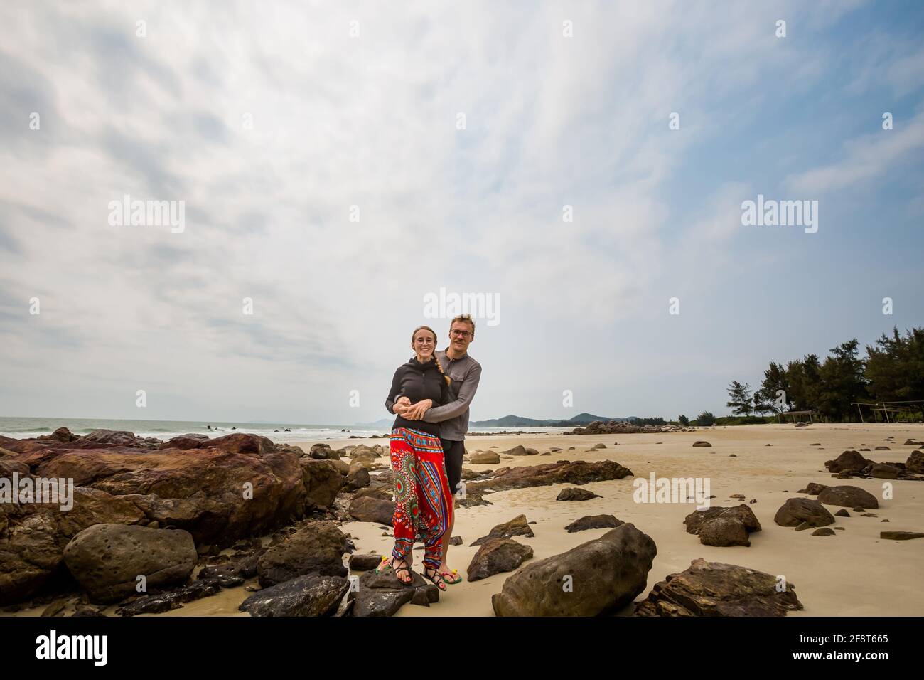 Felice coppia turistica sulla spiaggia di Son Hao, Quan LAN isola, Bai Tu Long Bay, Vietnam. Foto del paesaggio marino scattata nel sud-est asiatico, area di ha Long. Foto Stock