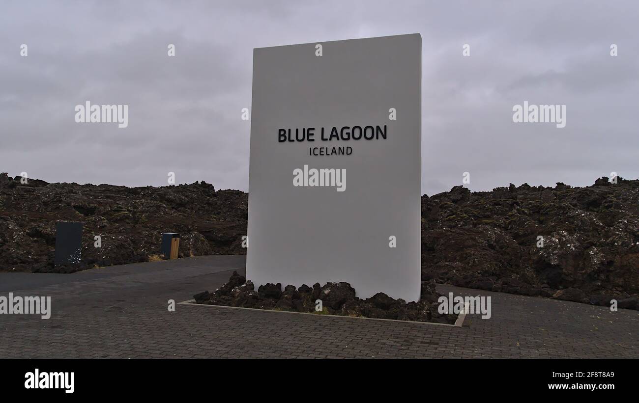 Vista del cartello di benvenuto all'ingresso della Blue Lagoon turistica con rocce vulcaniche di colore nero nel giorno invernale nuvoloso. Foto Stock