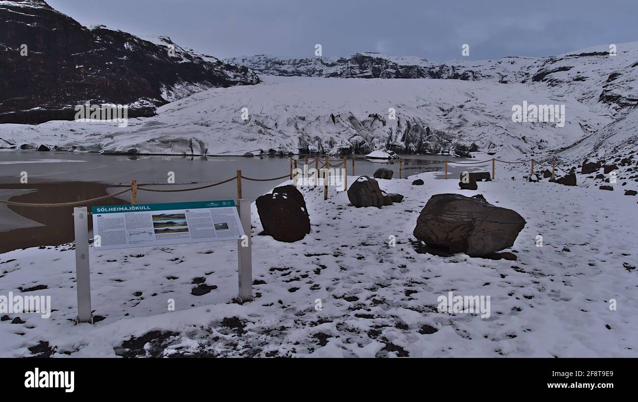Bella vista di Solheimajokull, un ghiacciaio di uscita di Mýrdalsjökull, dal punto di vista con un cartello informativo sul giorno nuvoloso nella stagione invernale. Foto Stock