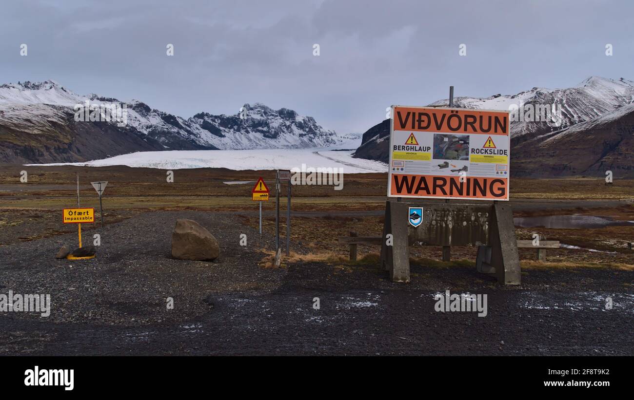 Strada chiusa per Svinafellsjökull con grande cartello di avvertimento durante la stagione invernale con ghiacciaio Skaftafellsjökull e aspre montagne innevate. Foto Stock