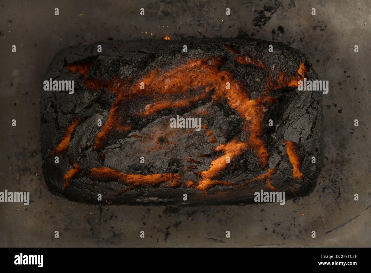 Fotografia di cibo scuro, pane al forno marrone e nero. Moody mattina cibo. Foto Stock