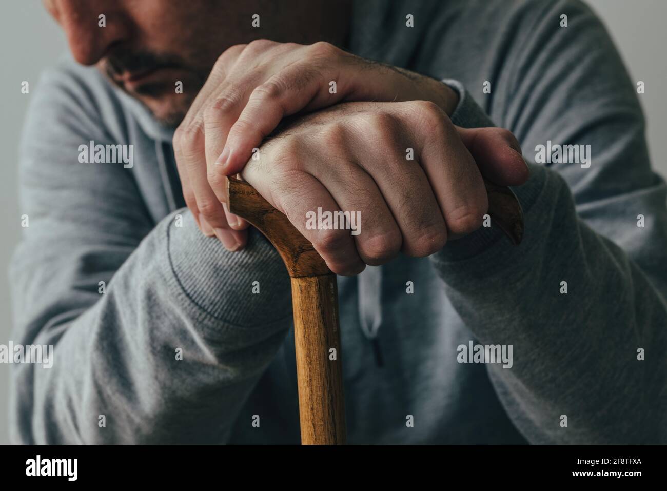 Uomo che tiene il bastone da passeggio, primo piano delle mani con messa a fuoco selettiva Foto Stock
