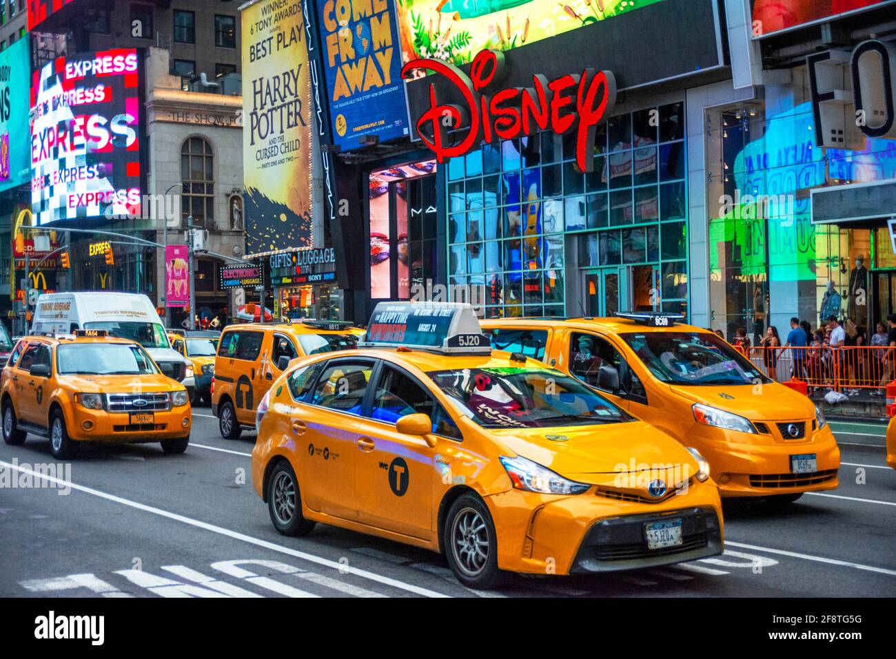 Questo negozio Disney si trova a Manhattan in Times Square nel cuore della Grande Mela. Taxi sulla trafficata Broadway di fronte al negozio New York Manhatt Foto Stock