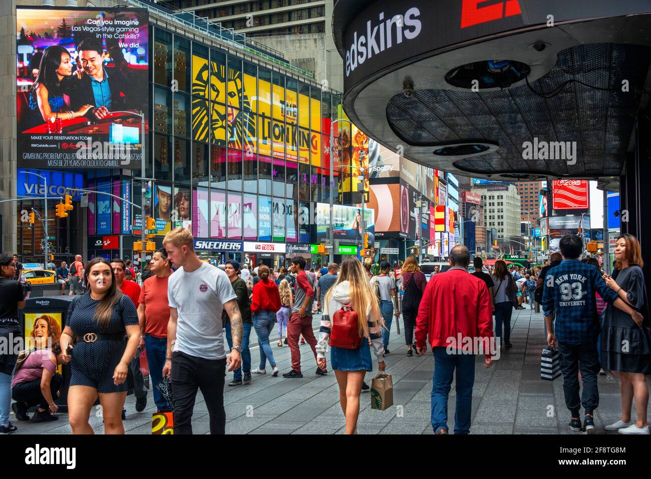 I visitatori e i turisti si divertono nella affollata Times Square, 42nd Street a Manhattan, New York City. Foto Stock