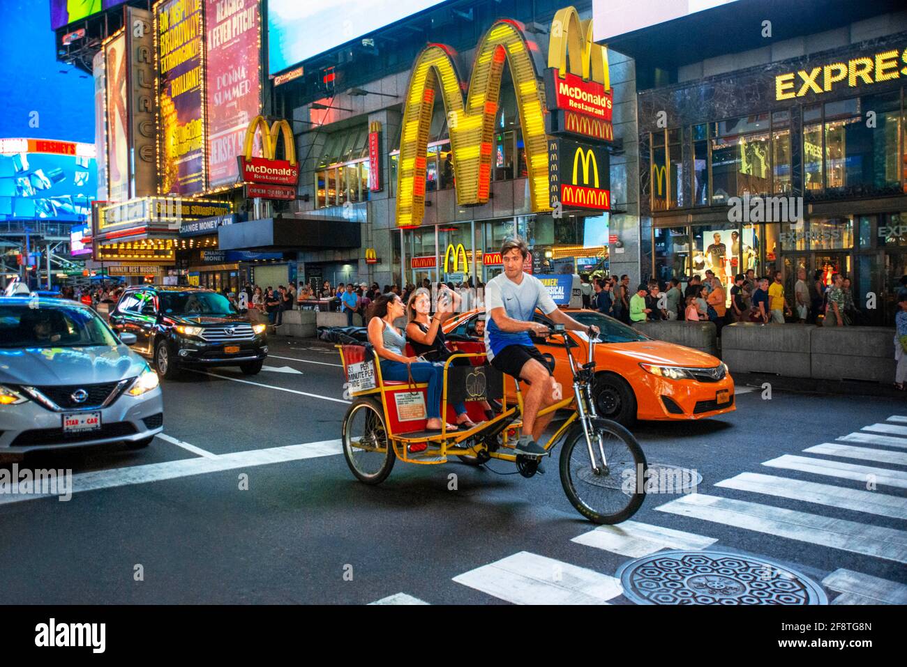 McDonald's fast foot Restaurant situato a Manhattan in Times Square nel cuore della Grande Mela. Pedicabs taxi sulla trafficata Broadway di fronte alla st Foto Stock
