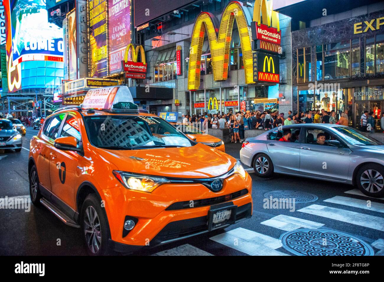 McDonald's fast foot Restaurant situato a Manhattan in Times Square nel cuore della Grande Mela. Taxi sulla trafficata Broadway di fronte al negozio New Y Foto Stock