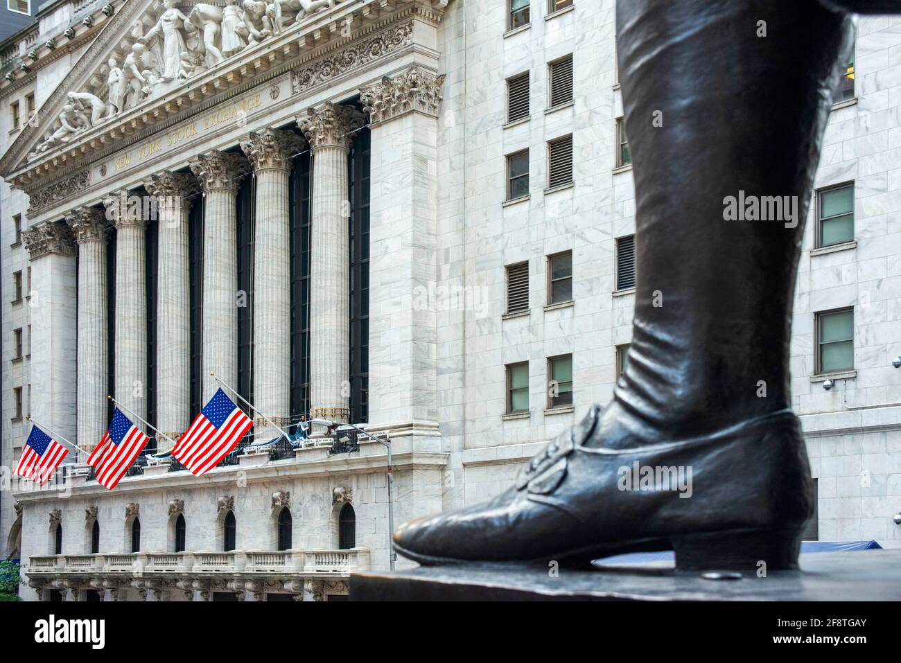 Una vista di Wall Street dai gradini della Federal Hall e i piedi della statua di George Washington in Di fronte all'edificio storico della Sala Federale NE Foto Stock