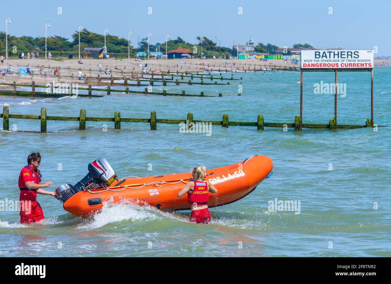 I bagnini di RNLI preparano una costola per affrontare un incidente in mare durante una giornata estiva al mare britannico a Littlehampton, West Sussex, Inghilterra, Regno Unito. Foto Stock