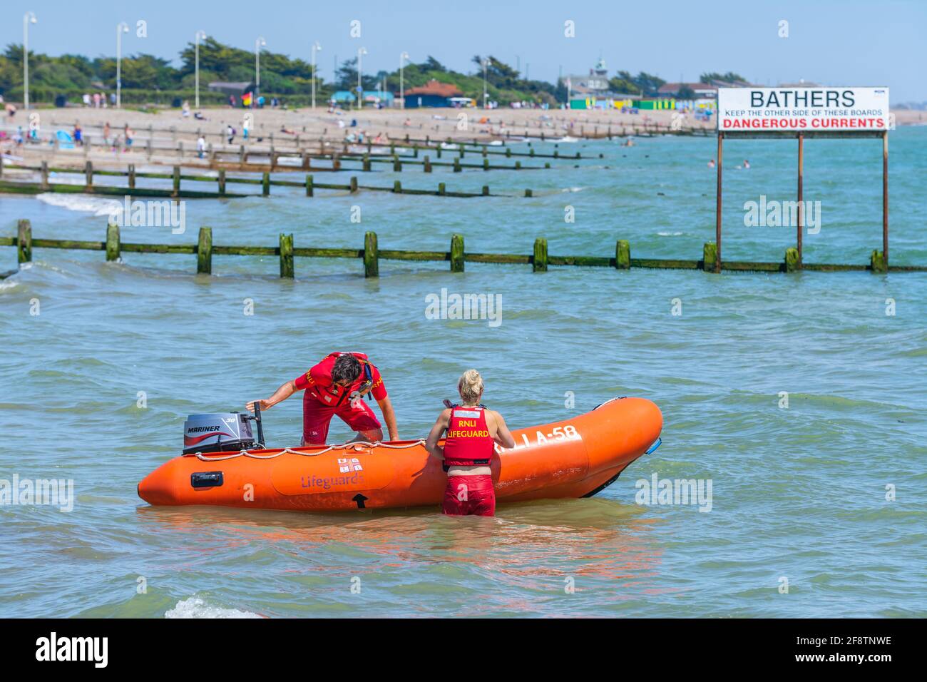 I bagnini di RNLI preparano una costola per affrontare un incidente in mare durante una giornata estiva al mare britannico a Littlehampton, West Sussex, Inghilterra, Regno Unito. Foto Stock