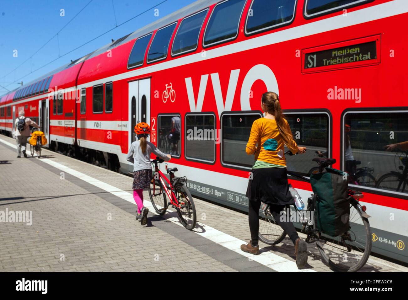 Una famiglia in moto viaggia in treno regionale, una madre e una figlia in una stazione ferroviaria in Germania Sassonia Foto Stock