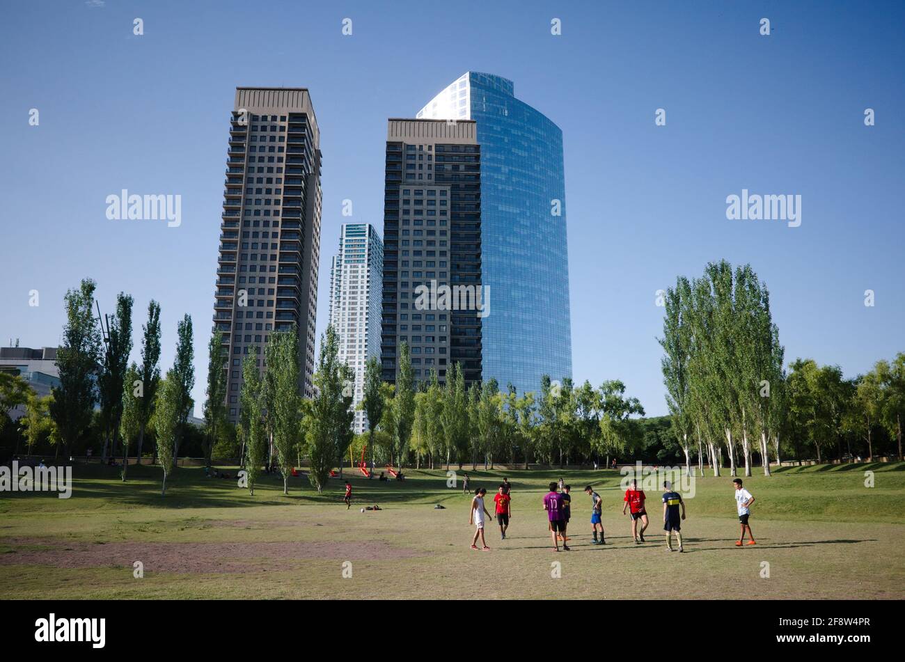 Buenos Aires, Argentina - Gennaio, 2020: Bambini che giocano a calcio nel parco pubblico.grattacieli del quartiere di Puerto Madero sullo sfondo Foto Stock
