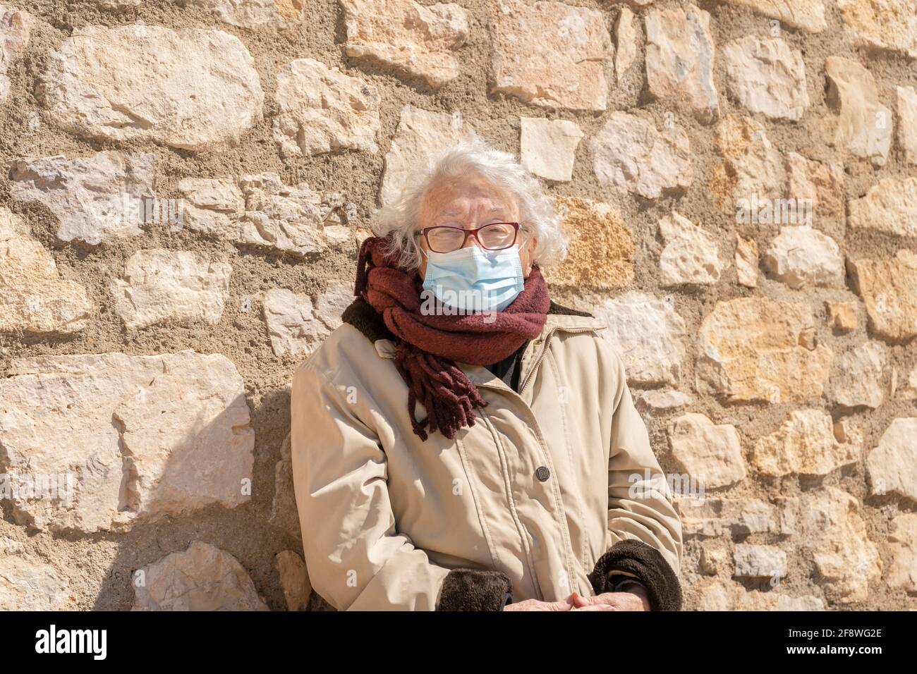 Ritratto di donna anziana, anni 80, con maschera medica viso durante pandemia di coronavirus Foto Stock