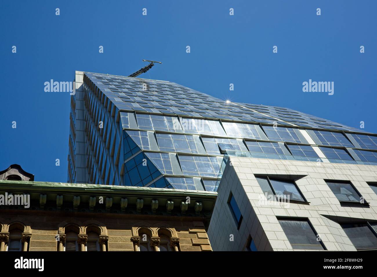 New York, NY, USA - 14 aprile 2021: Edificio chiamato 35XV, residenziale sulla parte superiore, scuola superiore sotto con una gru permanente sul tetto Foto Stock