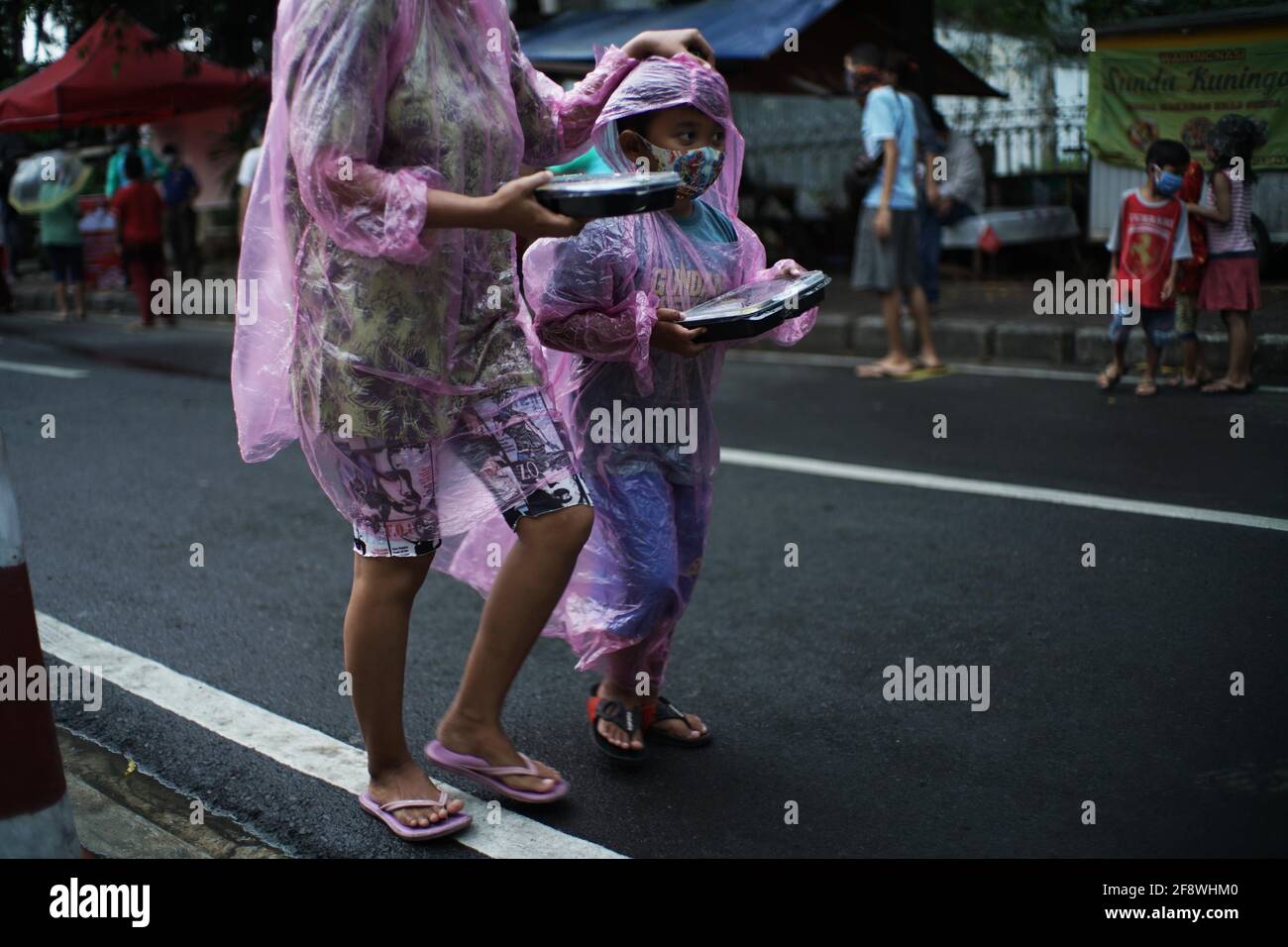 Giacarta, DKI Jakarta, Indonesia. 15 Aprile 2021. I residenti si accodano applicando la regola della distanza per ottenere il takjil libero sulle strade del centro di Giacarta, giovedì (04/15/2021). I residenti sono obbligati ad accodarsi applicando una distanza di due metri per prevenire la diffusione del coronavirus. Eeveryday la commissione fornisce 400-600 pacchetti takjil gratuitamente che sono donazioni da residenti e società nella regione. Credit: Muhammad Zaenuddin/ZUMA Wire/Alamy Live News Foto Stock