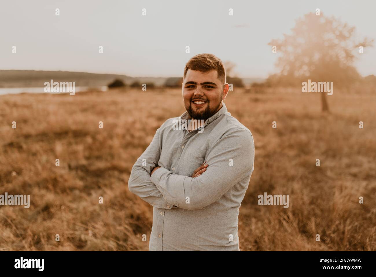 giovane uomo in sovrappeso caucasico dai capelli neri con barba sorridente in estate vestiti di cotone e pantaloncini all'aperto in tempo soleggiato. uomini moda co Foto Stock