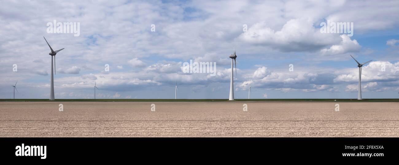 Azienda eolica con mulini a vento lungo la diga sulla costa Del Ijsselmeer in una bella giornata limpida i Paesi Bassi Flevoland Noordoostpolder e beautu Foto Stock