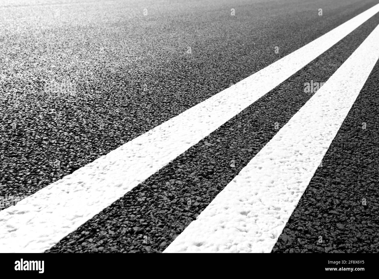 Strada asfaltata con linee di marcatura strisce bianche. Foto Stock