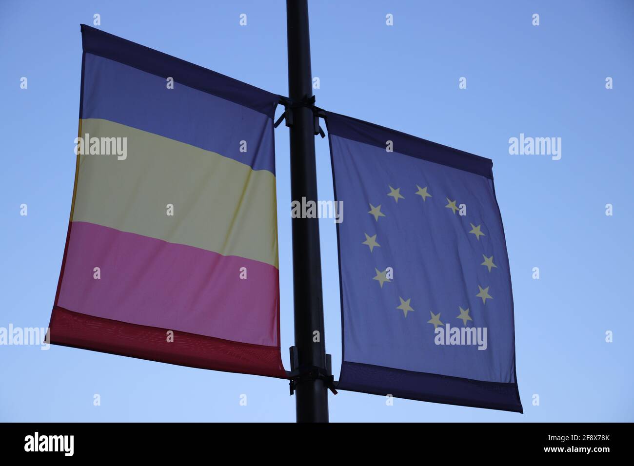 Bandiera europea e bandiera rumena gettano su un palo Foto Stock