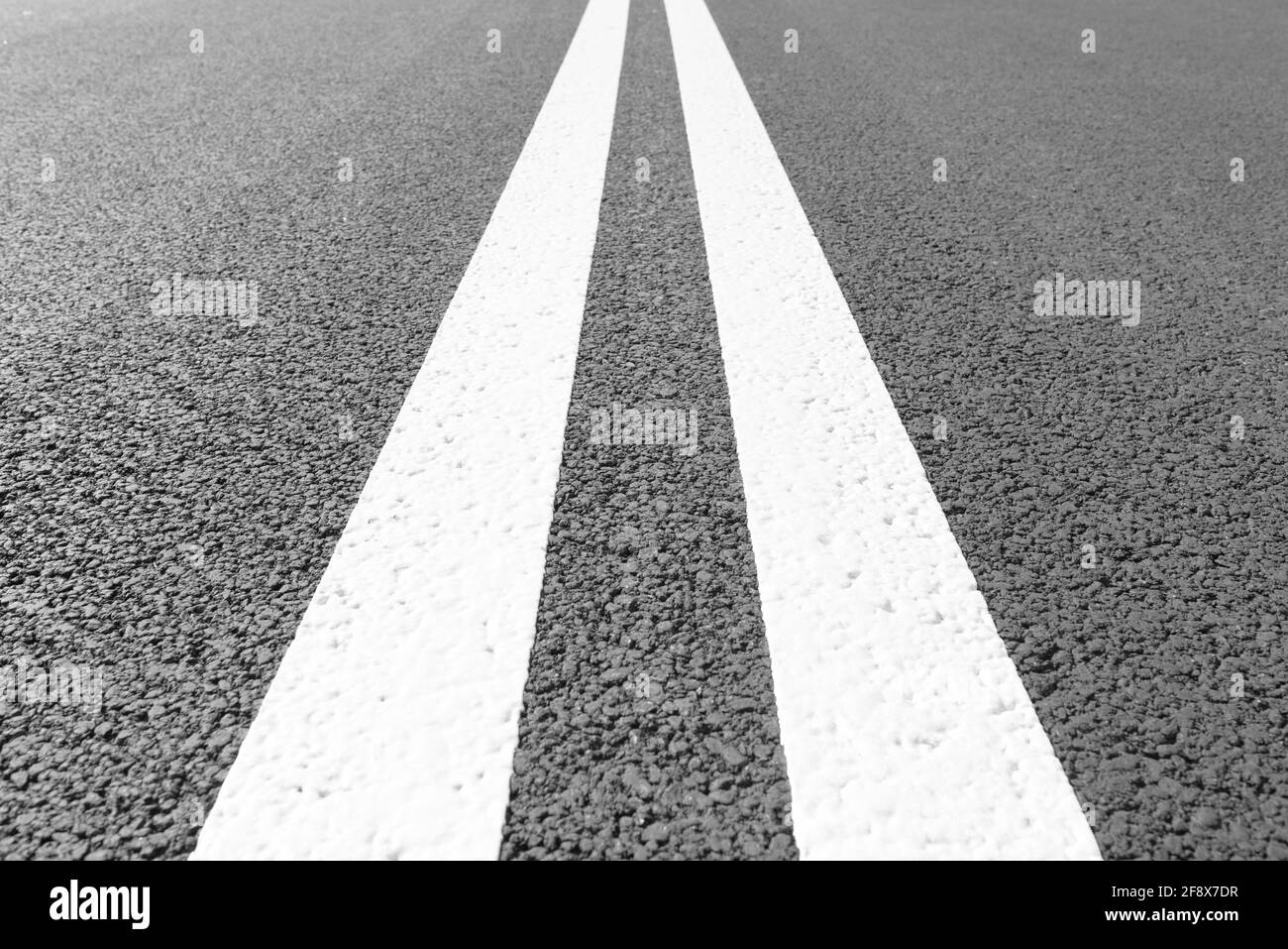Strada asfaltata con linee di marcatura strisce bianche. Foto Stock